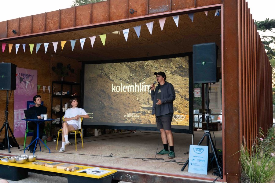 Prednášajúci na pódiu pred plátnom s názvom kolemhlíny