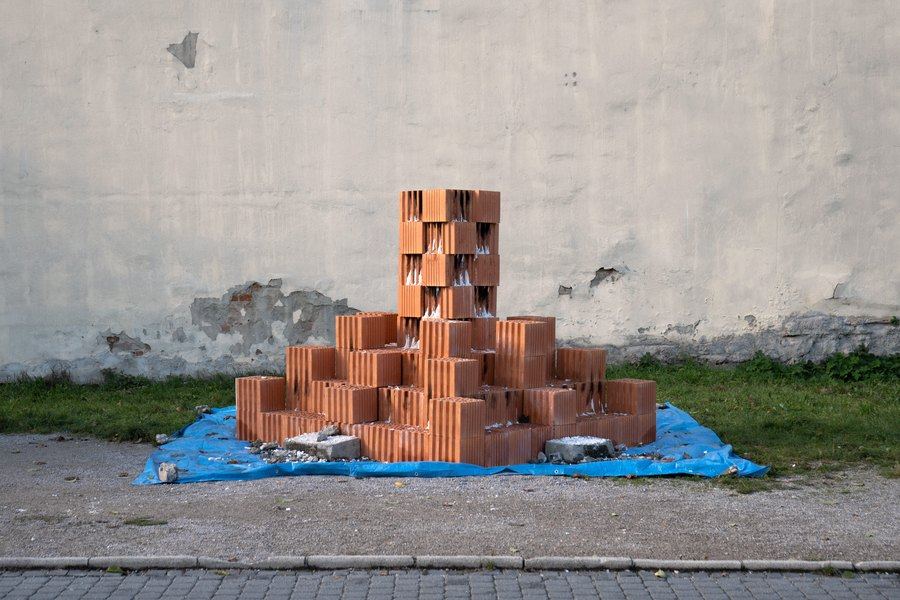 Terakotové tvarovky poskladané do veže a pyramídy na modrej plachte